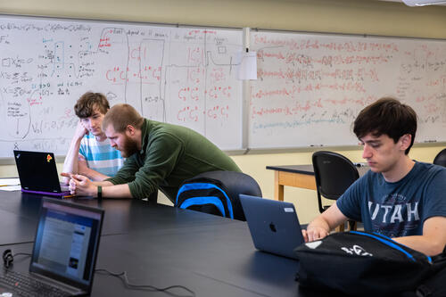 Thomas Osburn, assistant professor of physics and astronomy and two students at a lab.