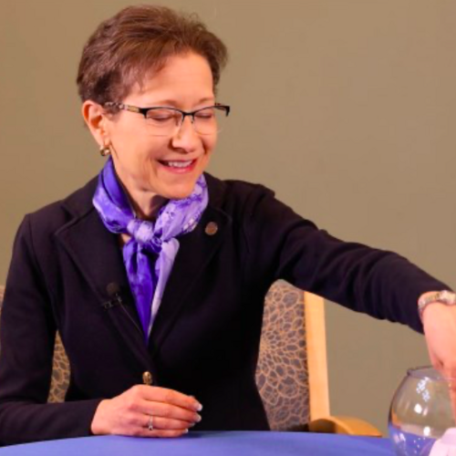 President Denise Battles choosing a question printed on a piece paper from a bowl.